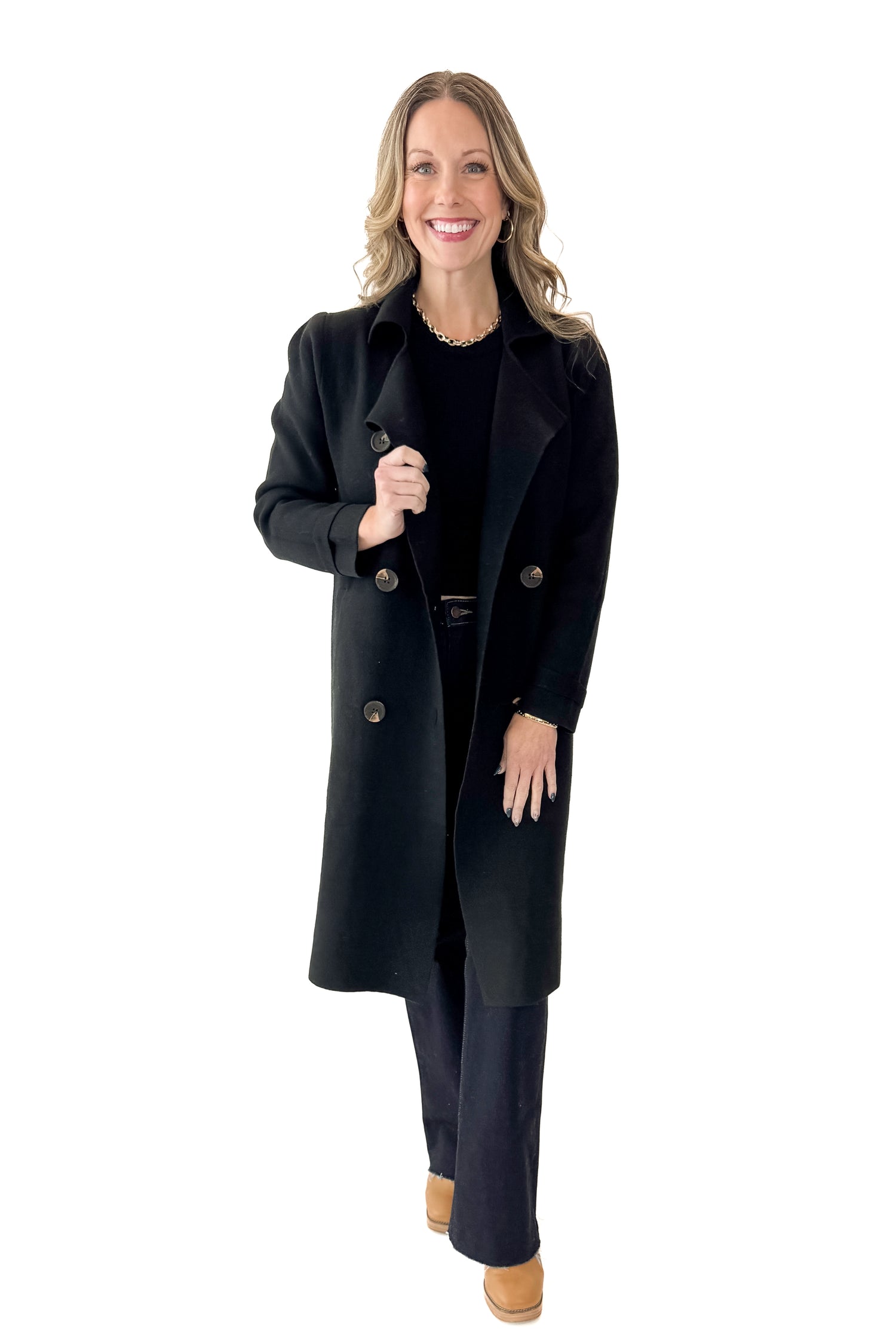 Front view of woman wearing Black Long Peacoat with jeans against white studio background.