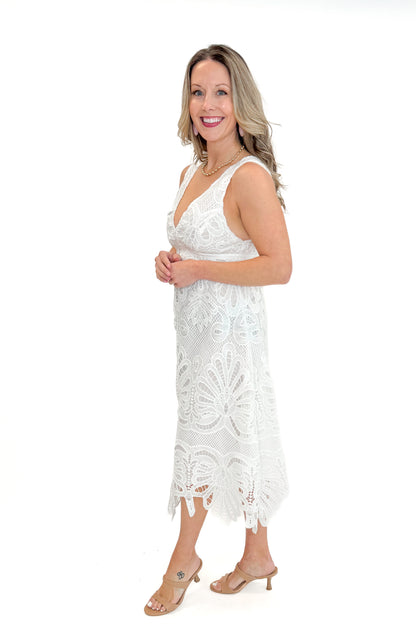 Side view of woman wearing White Embroidered Lace V-neck Dress by Skies Are Blue against white studio background.