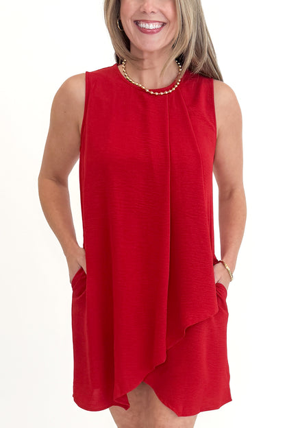 Front detail view of woman wearing Red Pleat Detail Shift Dress against white studio background.