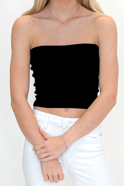 Front detail view of woman wearing Black Ribbed Tube Top with jeans against white studio background.