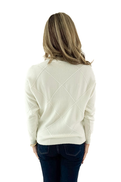 Back view of woman wearing Cream Diamond Mock Neck Sweater with jeans against white studio background