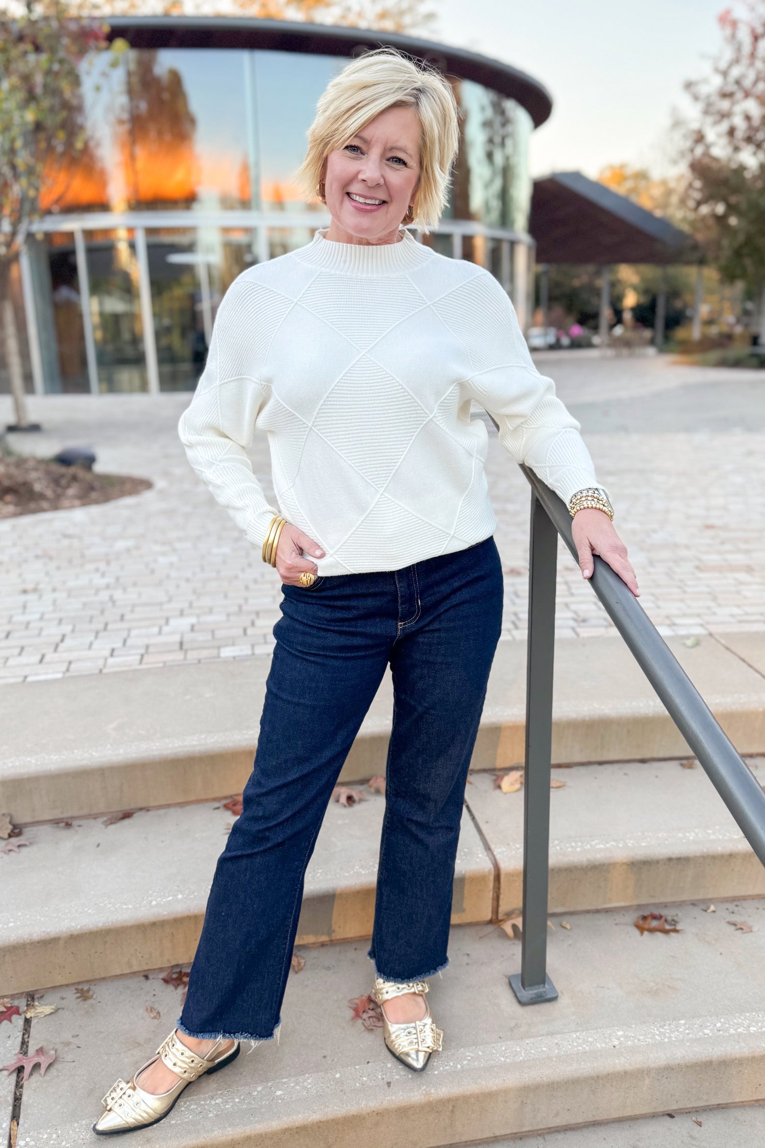 Front view of woman wearing Cream Diamond Mock Neck Sweater with jeans outside
