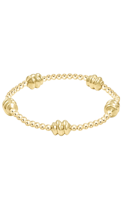 Gold bracelet on a plain white background