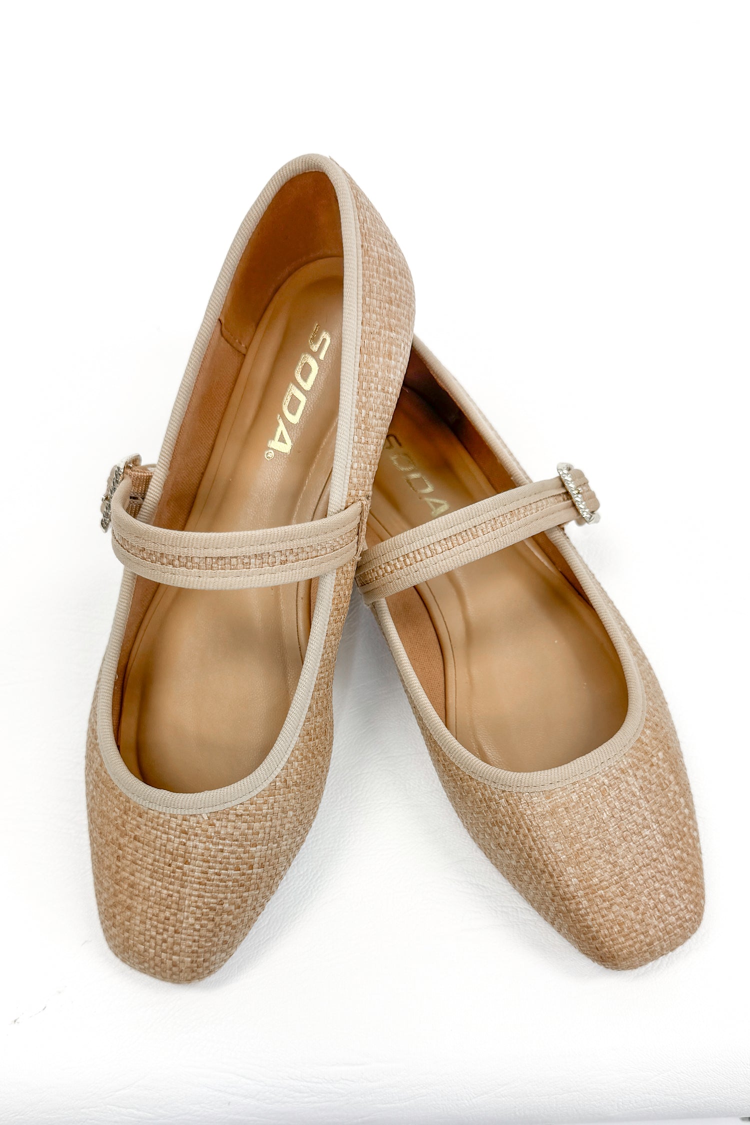 Adora- Natural Raffia Flats against white studio background.