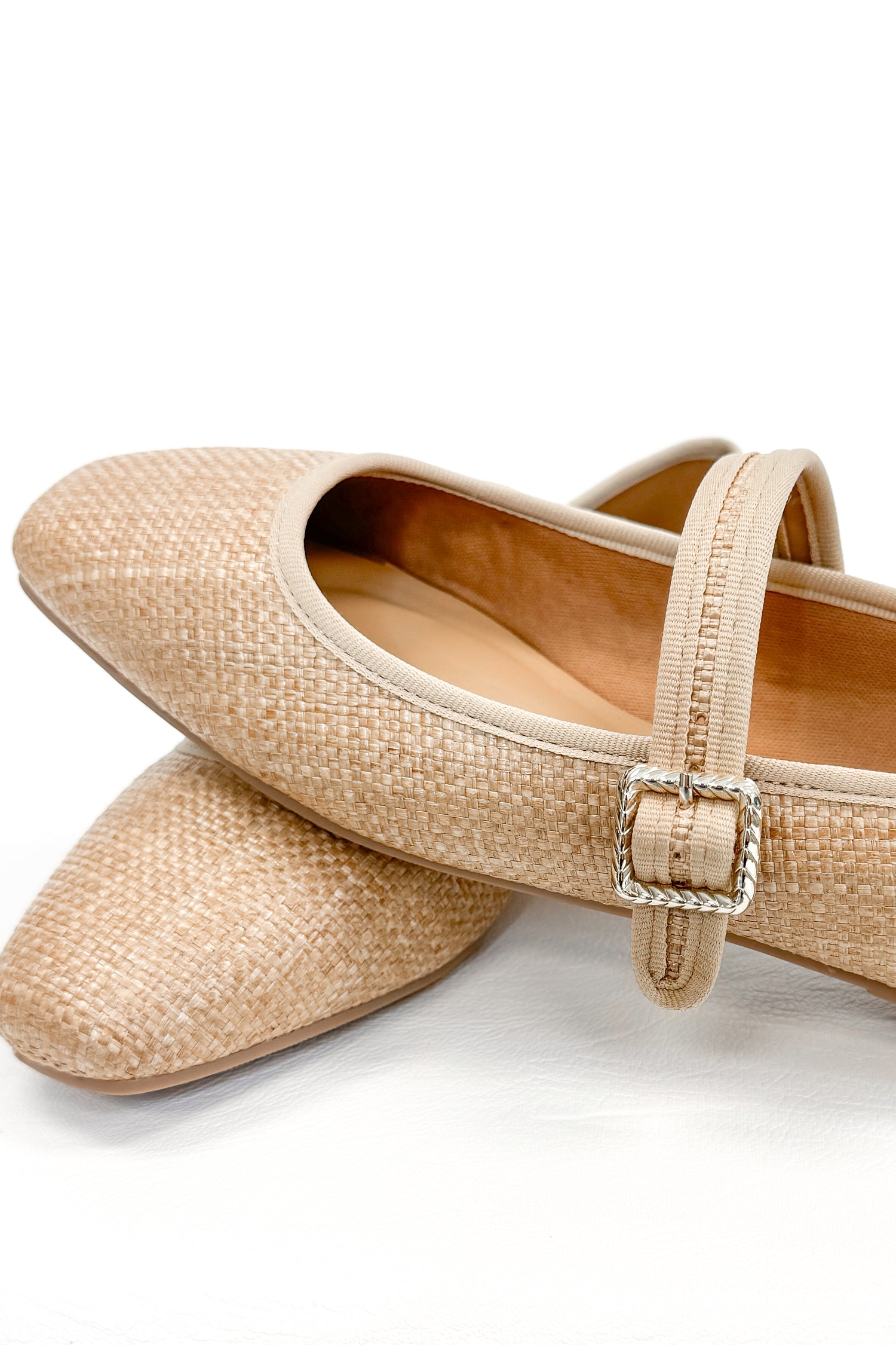 Adora- Natural Raffia Flats against white studio background close up.