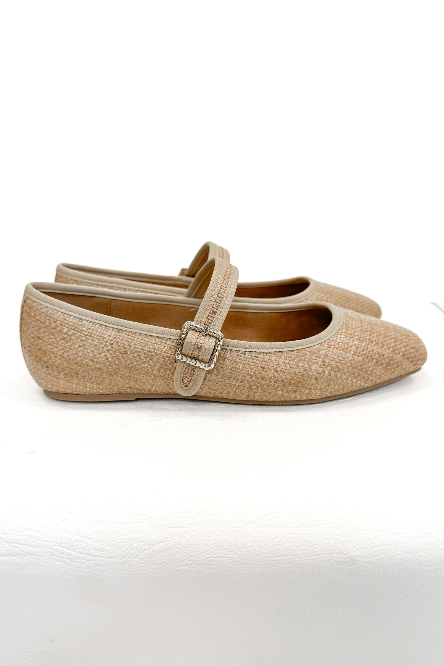 Adora- Natural Raffia Flats against white studio background side view.