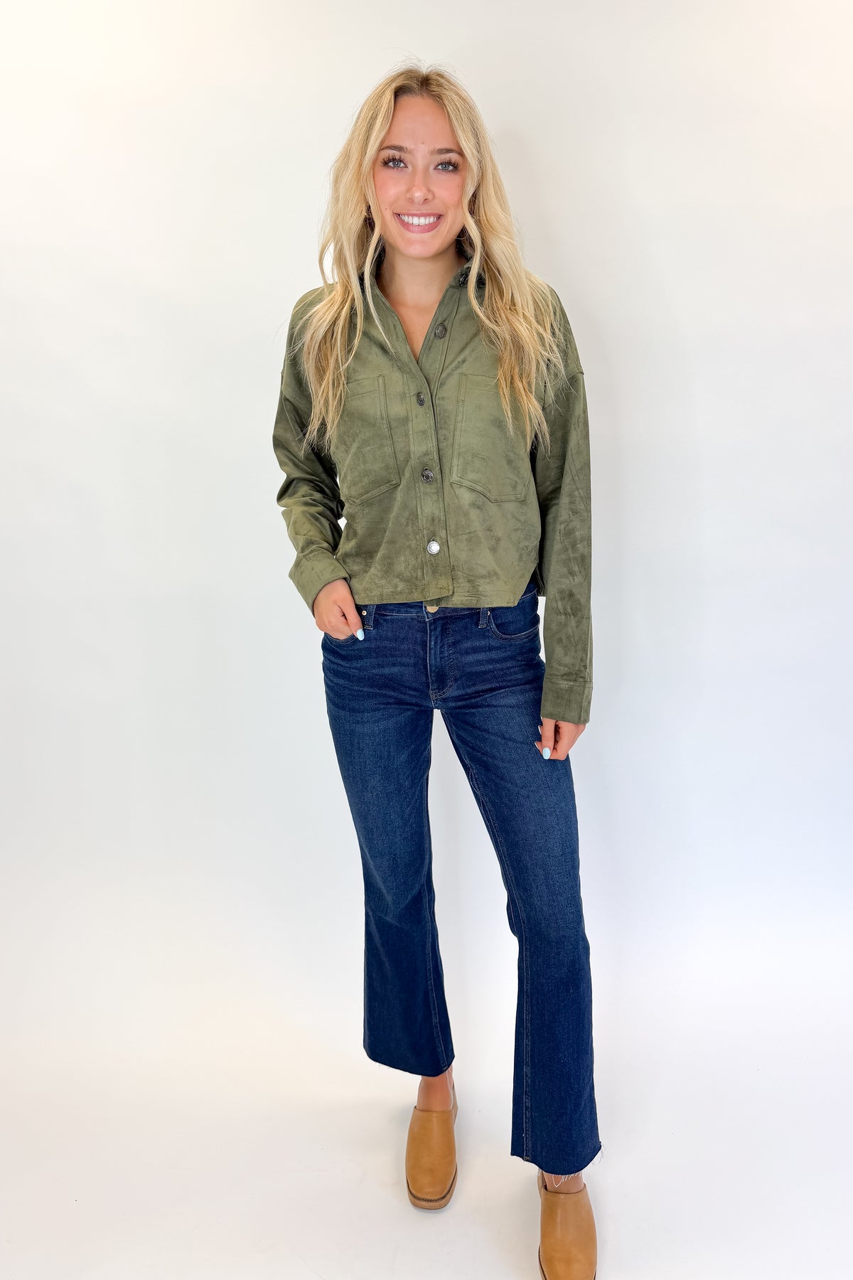 Front view of woman wearing Swagger Boutique’s Monstera All Day Cropped Suede Jacket by Z Supply with jeans against white studio background.