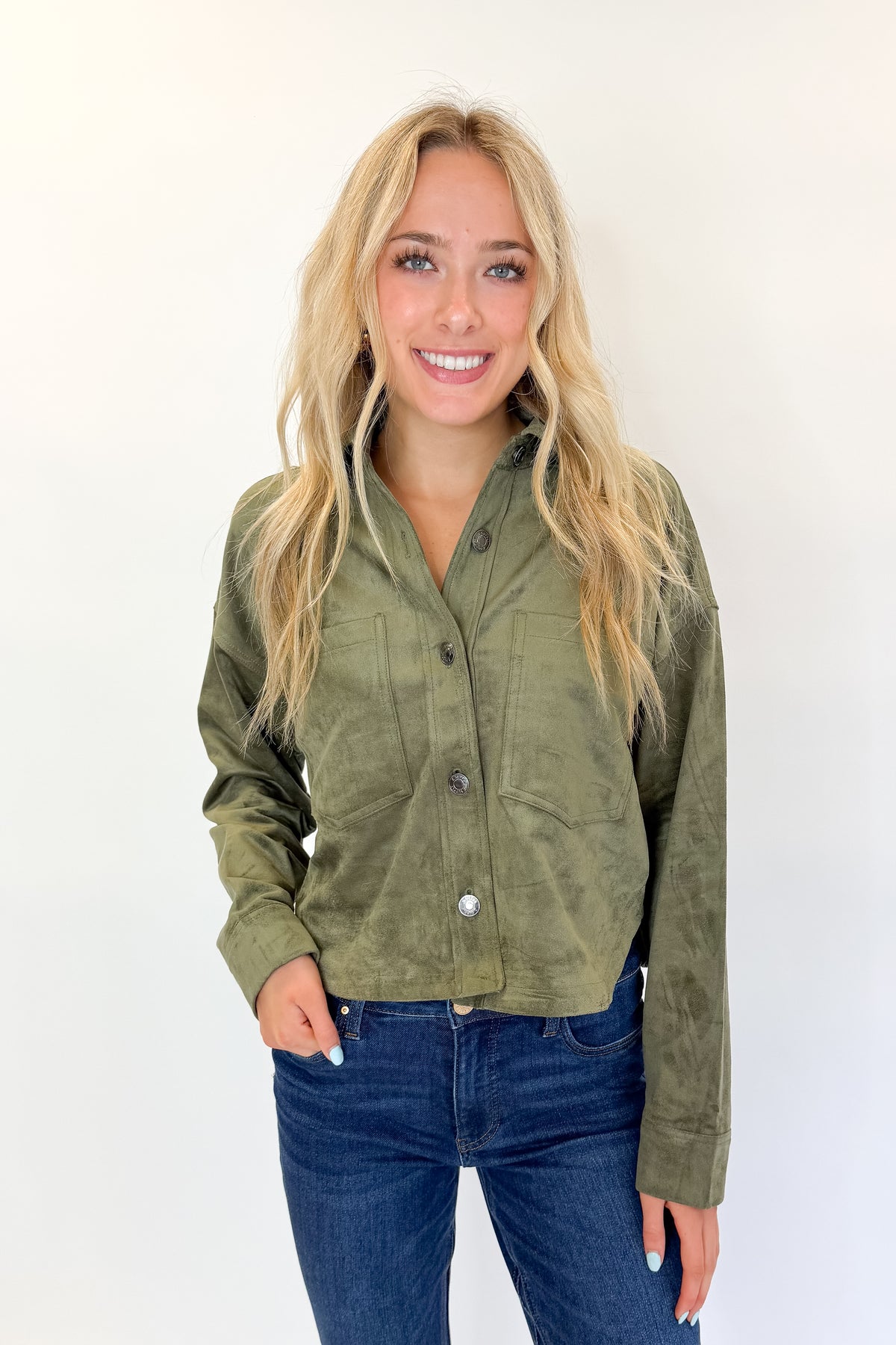 Front view of woman wearing Swagger Boutique’s Monstera All Day Cropped Suede Jacket by Z Supply with jeans against white studio background.