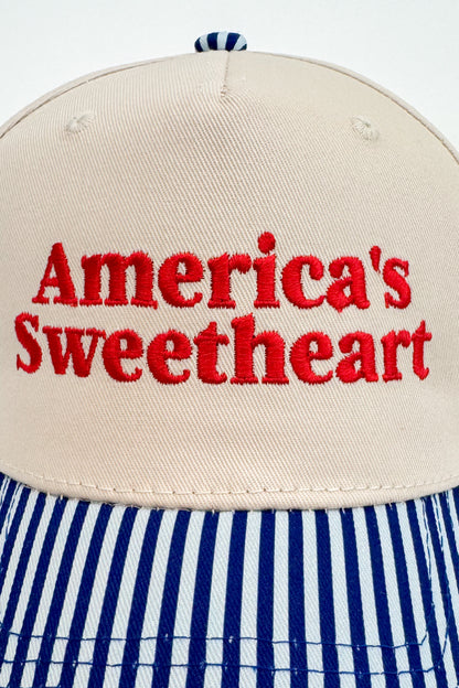 Close-up of the “America’s Sweetheart” embroidery on the front of the striped-brim cap.