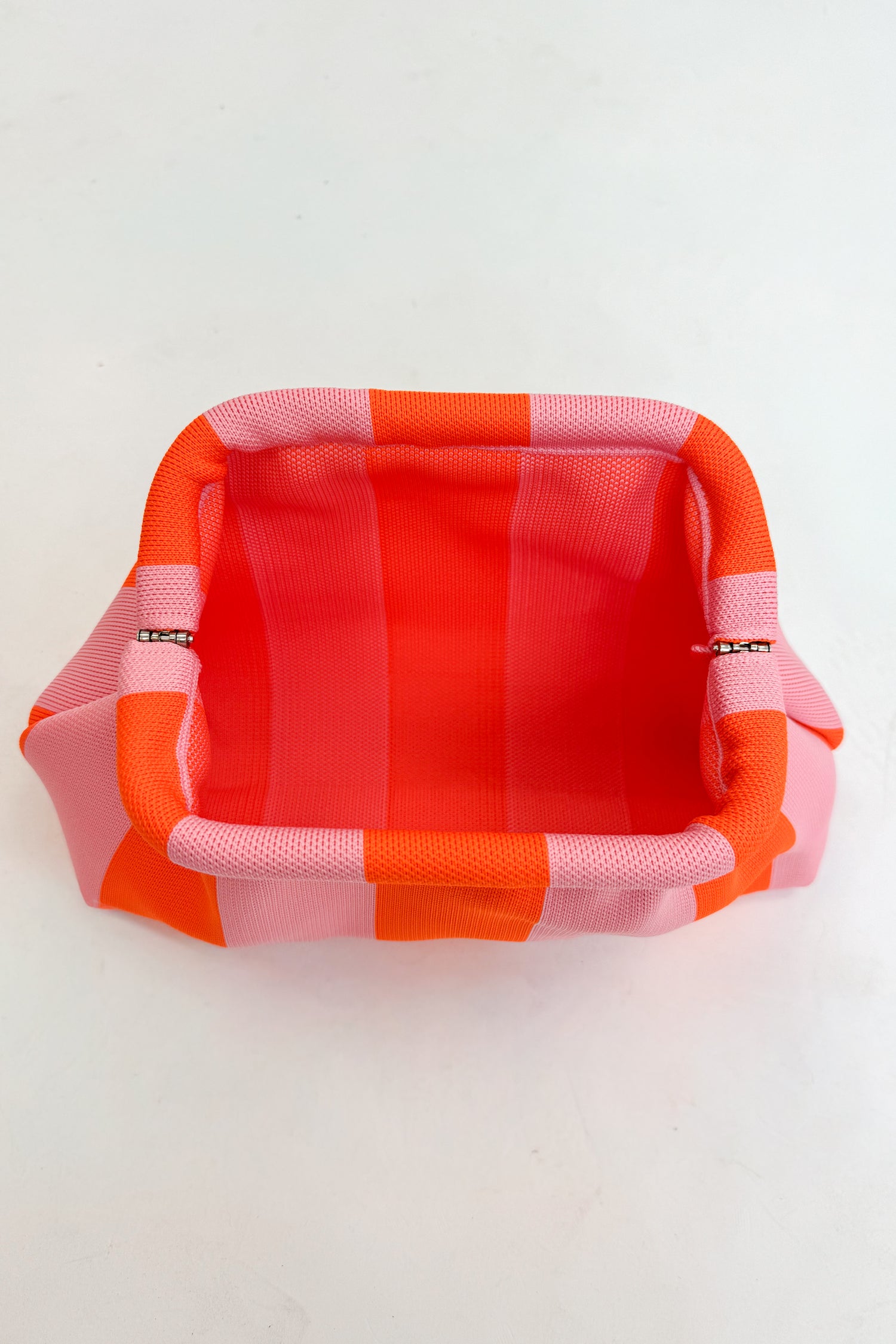 Rectangular fabric pouch with orange and pink striped pattern open on a white background
