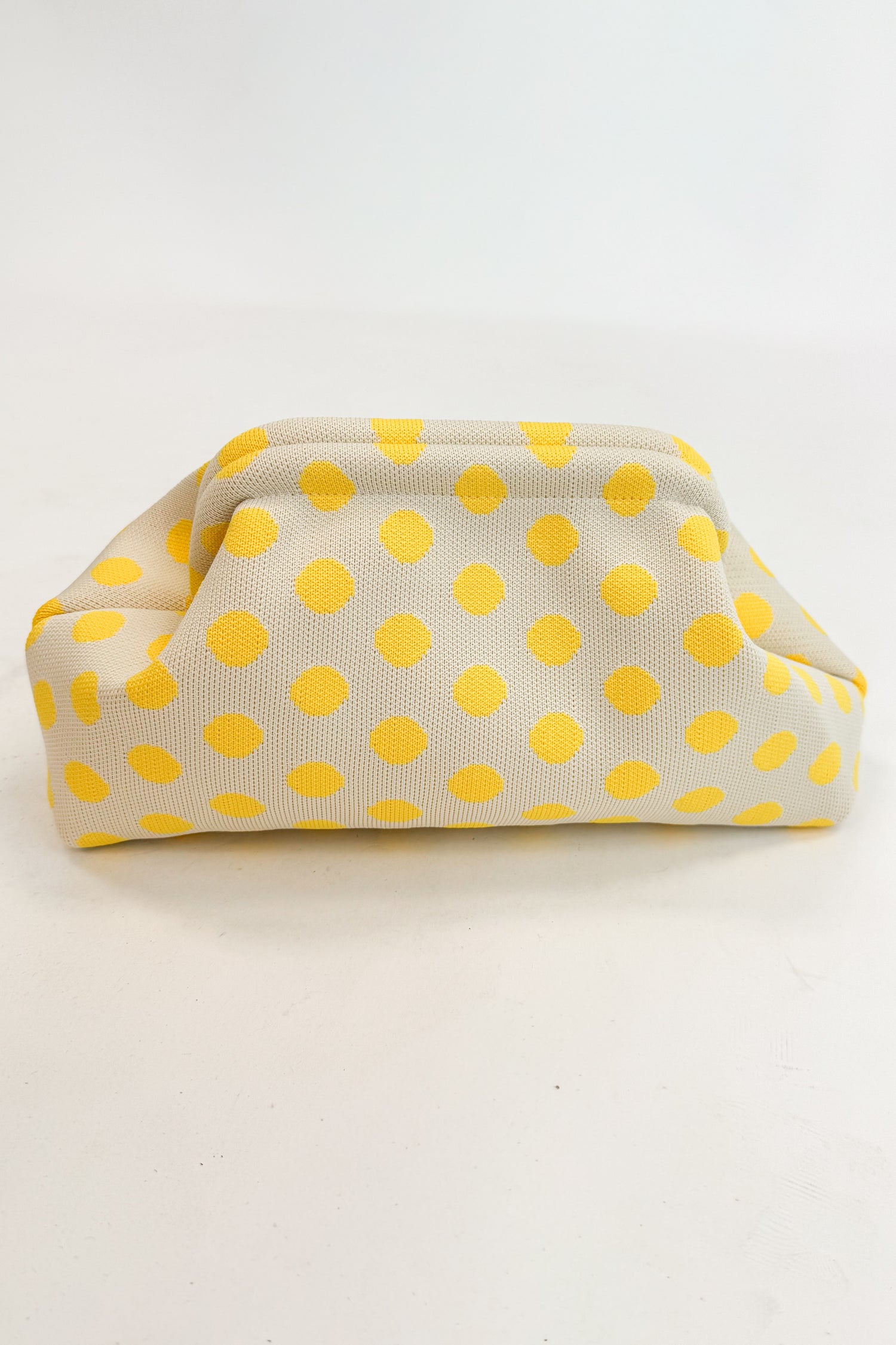 Beige fabric pouch with yellow polka dots on a white background