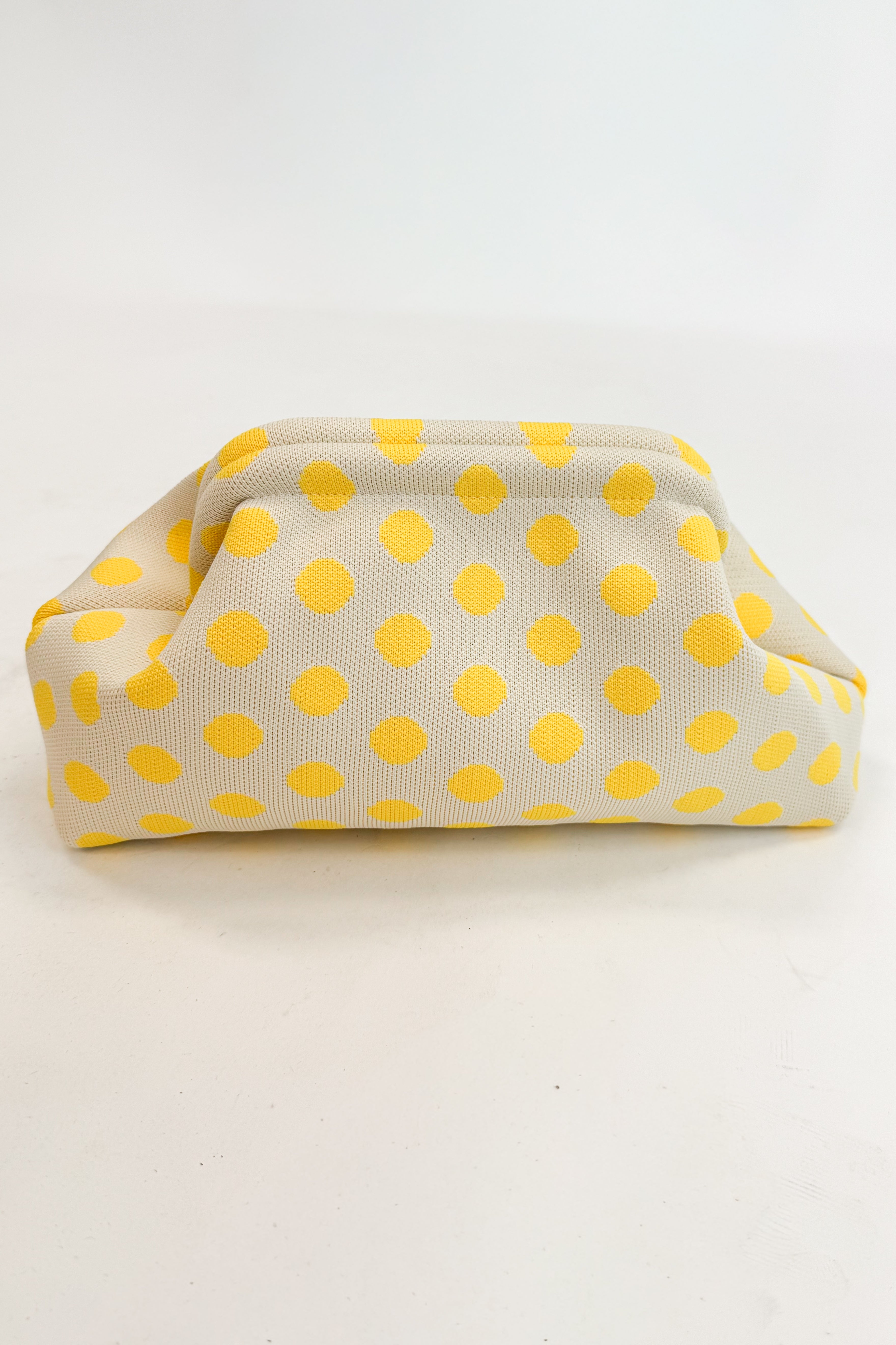 Beige fabric pouch with yellow polka dots on a white background