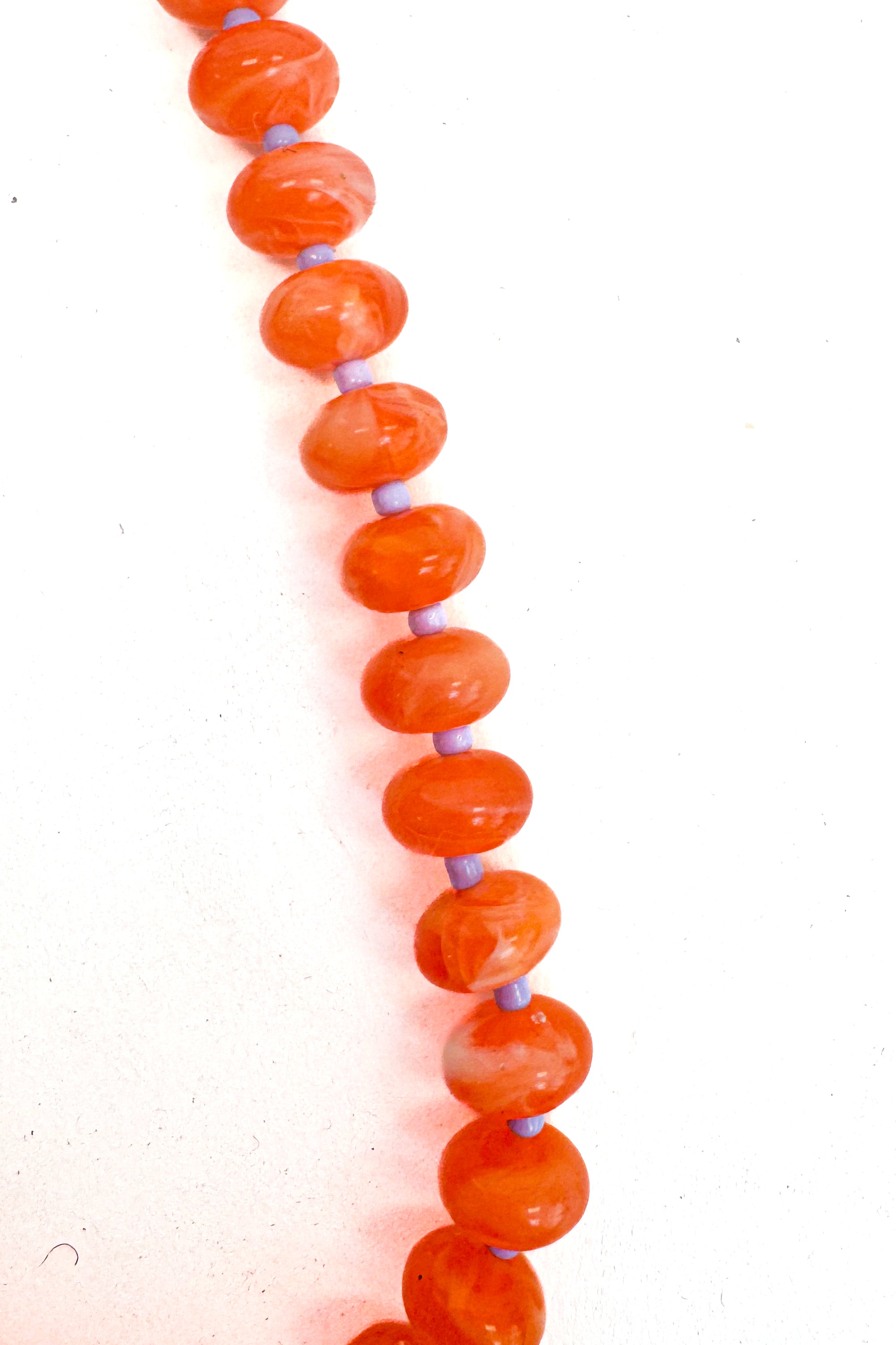 Necklace with orange beads on a white background