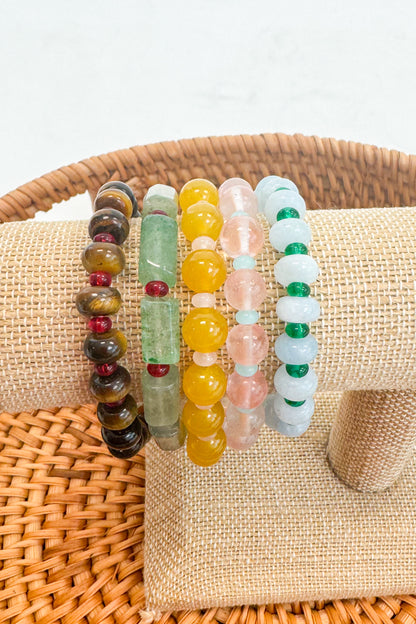 Set of colorful beaded bracelets on a beige fabric with a woven basket background