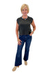 Front view of woman wearing Swagger Boutique’s Ash Black Flex Sleeveless Tee by Z Supply with jeans against white studio background.