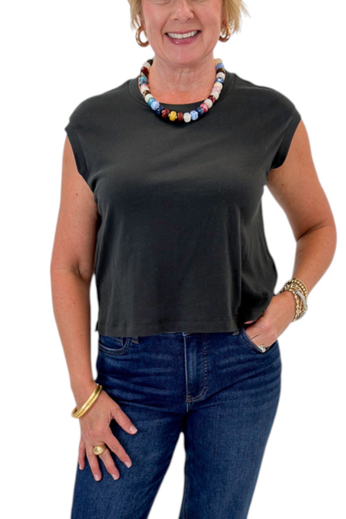 Front detail view of woman wearing Swagger Boutique’s Ash Black Flex Sleeveless Tee by Z Supply with jeans against white studio background.