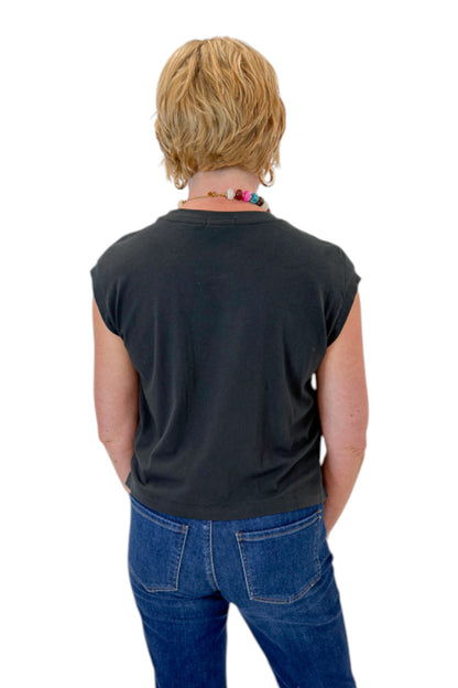 Back view of woman wearing Swagger Boutique’s Ash Black Flex Sleeveless Tee by Z Supply with jeans against white studio background.