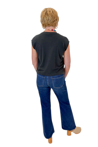 Back view of woman wearing Swagger Boutique’s Ash Black Flex Sleeveless Tee by Z Supply with jeans against white studio background.