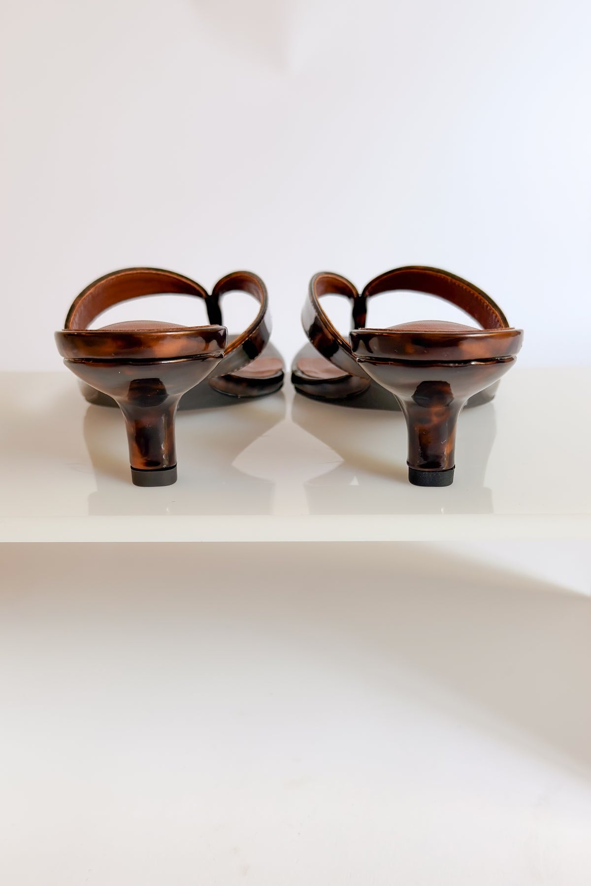 Azalea- Tortoise Thong Kitten Heel against white studio background back view.
