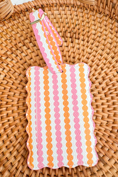 Striped pouch with pink and orange pattern on a woven surface