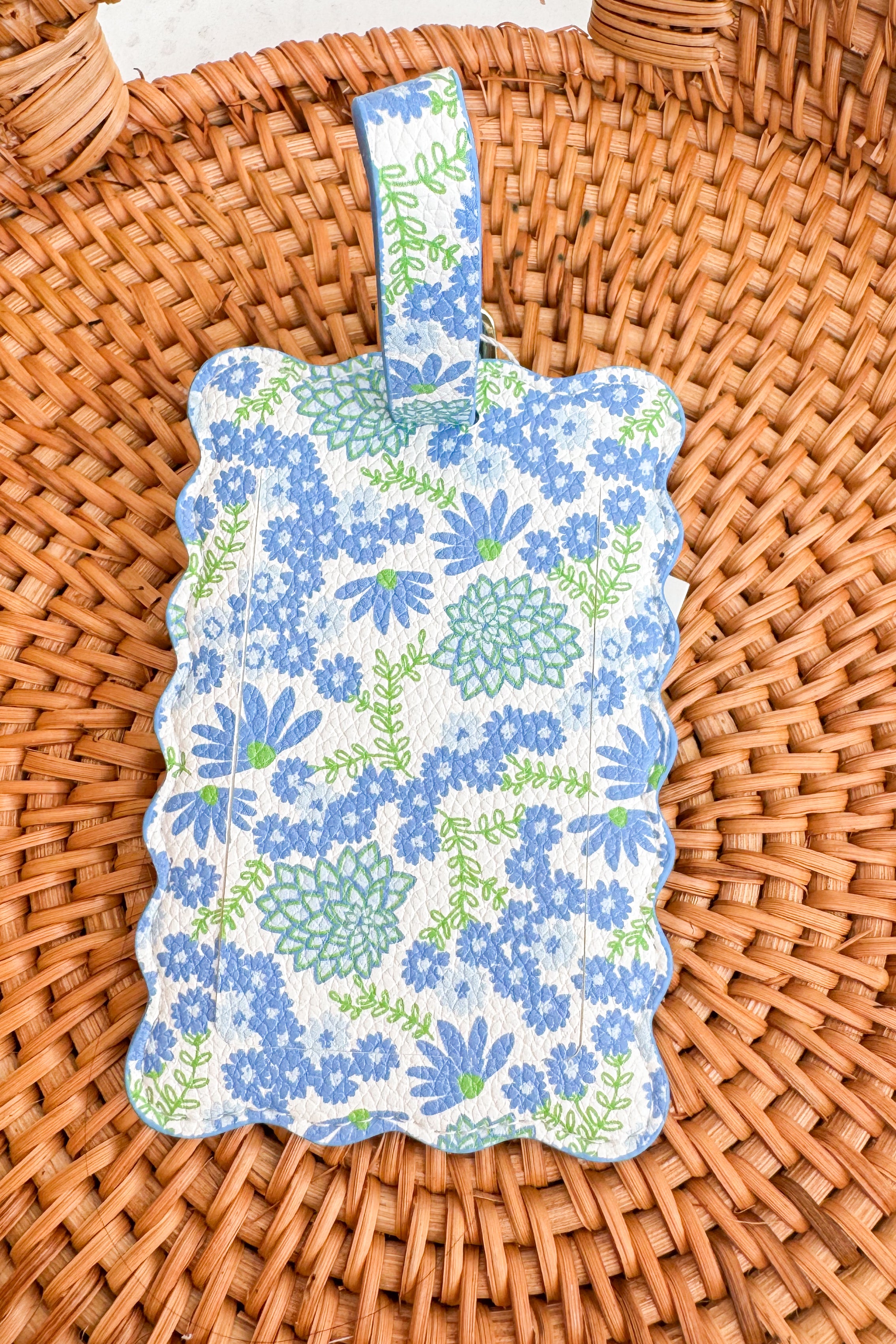 Floral-patterned luggage tag on a woven surface