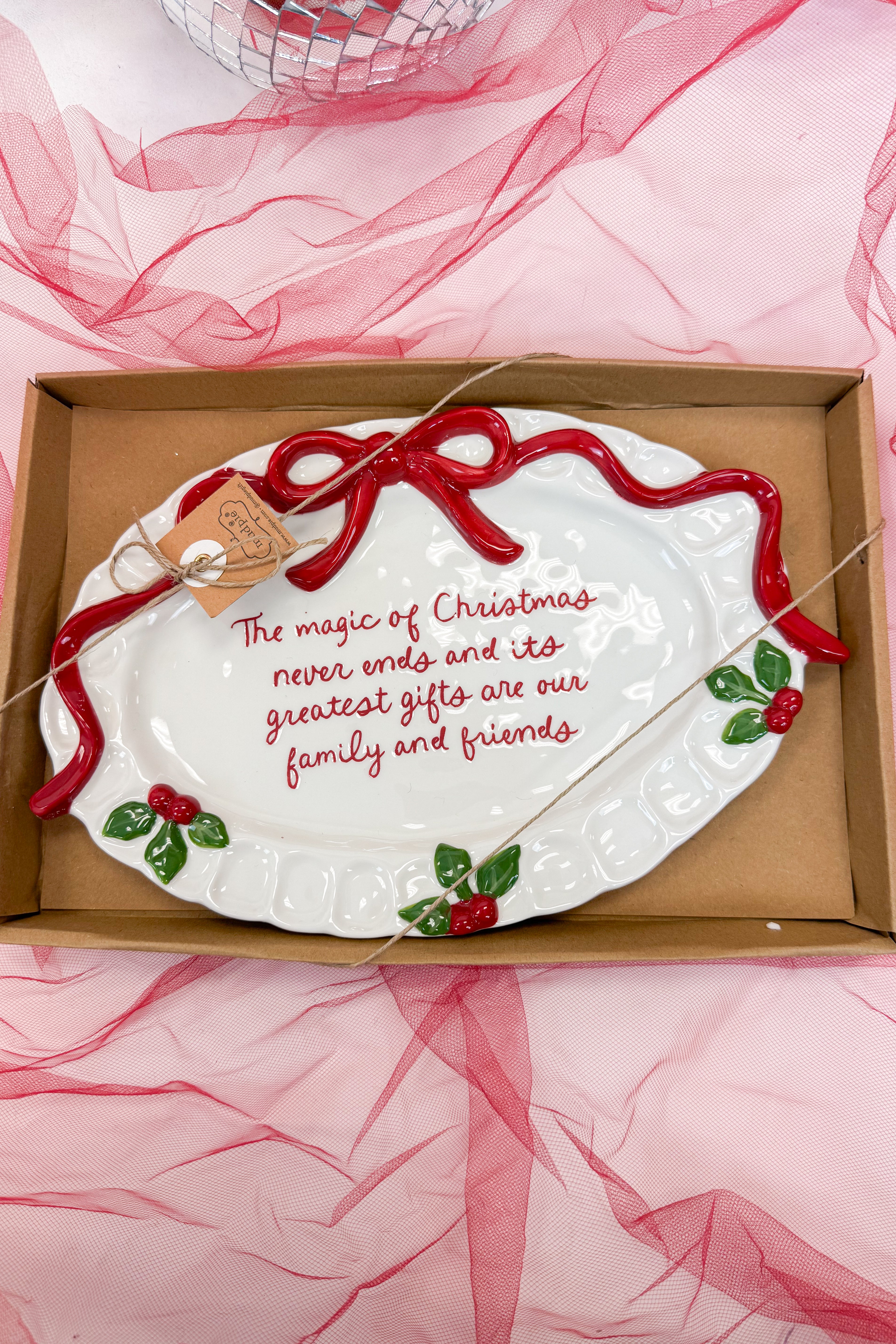 Decorative plate with Christmas message in a box on a pink fabric background