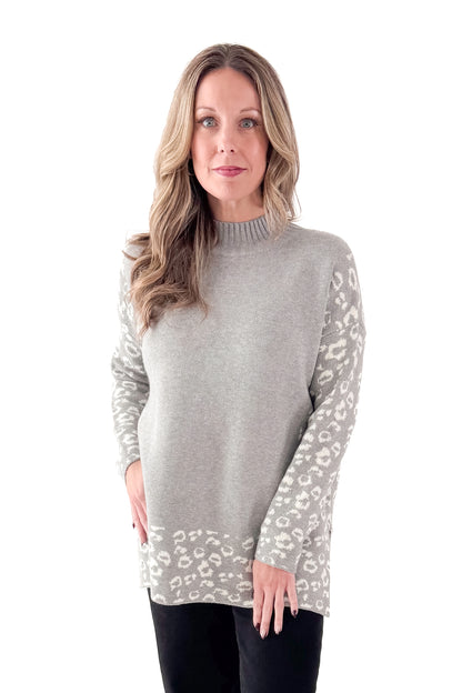 Front view of woman wearing Grey Leopard Print Lined Sweater with jeans against white studio background.