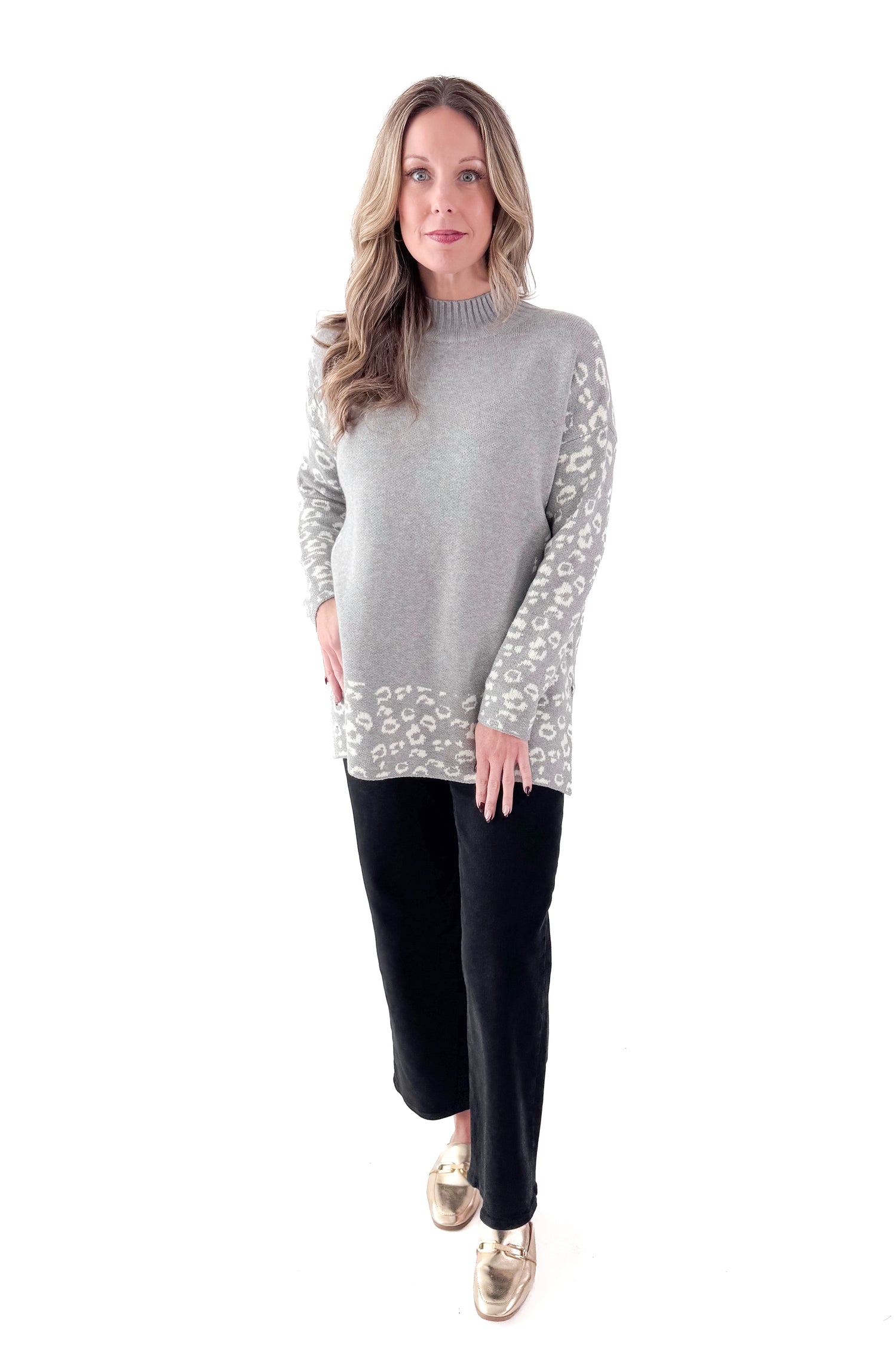 Front view of woman wearing Grey Leopard Print Lined Sweater with jeans against white studio background.