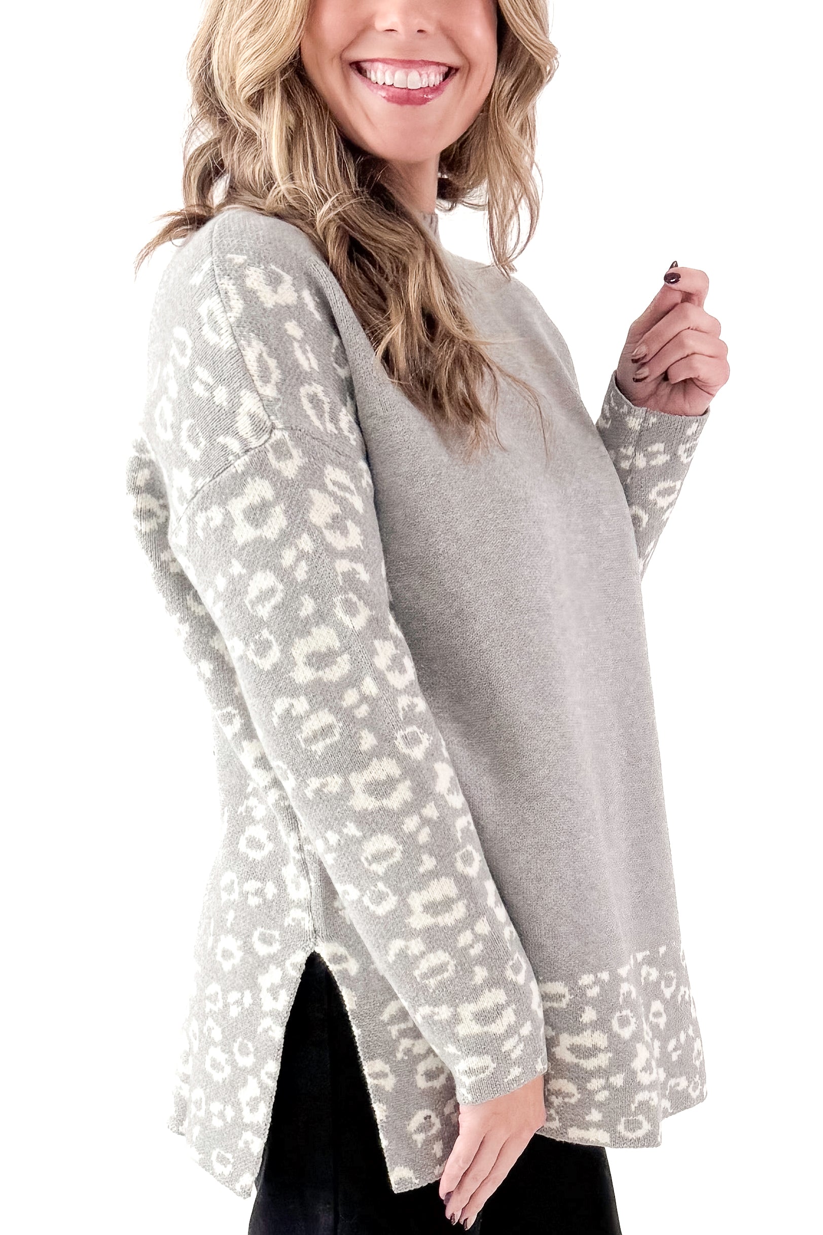 Side view of woman wearing Grey Leopard Print Lined Sweater with jeans against white studio background.
