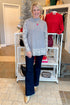 Front view of woman wearing Grey Leopard Print Lined Sweater with jeans at a boutique.
