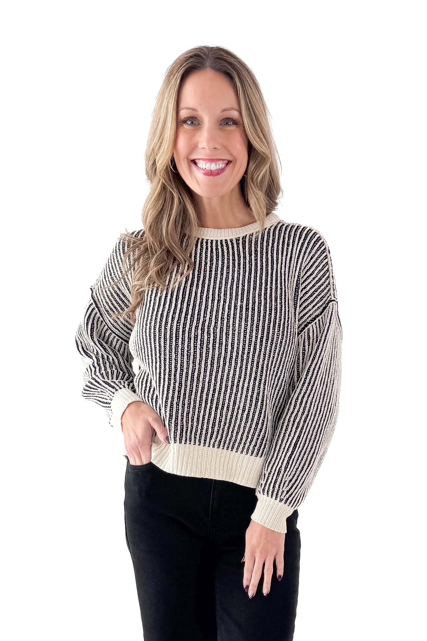 Front view of woman wearing Black &amp; Cream Striped Sweater with jeans against white studio background.