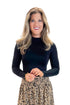 Front view of woman wearing Black Mock Neck Bodysuit with skirt against white studio background.