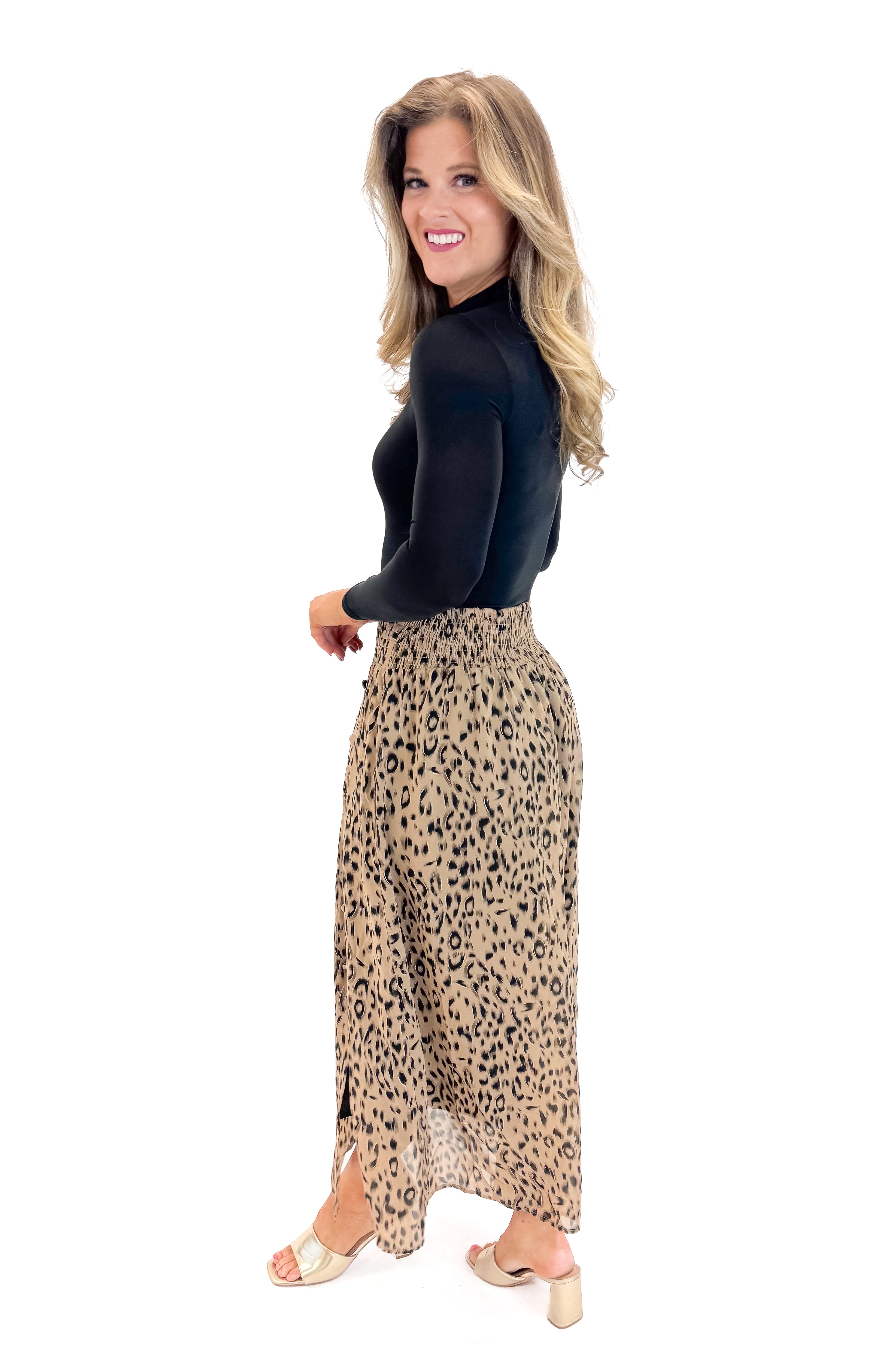 Side view of woman wearing Black Mock Neck Bodysuit with skirt against white studio background.