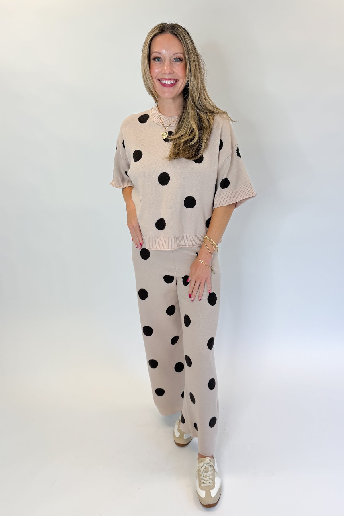 Front view of woman wearing Swagger Boutique’s Beige Polka Dot Short Sleeve Top &amp; Knit Pants against white studio background.