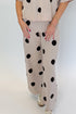 Front detail view of woman wearing Swagger Boutique’s Beige Polka Dot Short Sleeve Top & Knit Pants against white studio background.