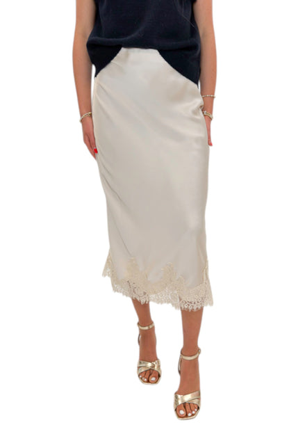 Front view of woman wearing Swagger Boutique’s Beige Satin &amp; Lace Midi Skirt with heels against white studio background.