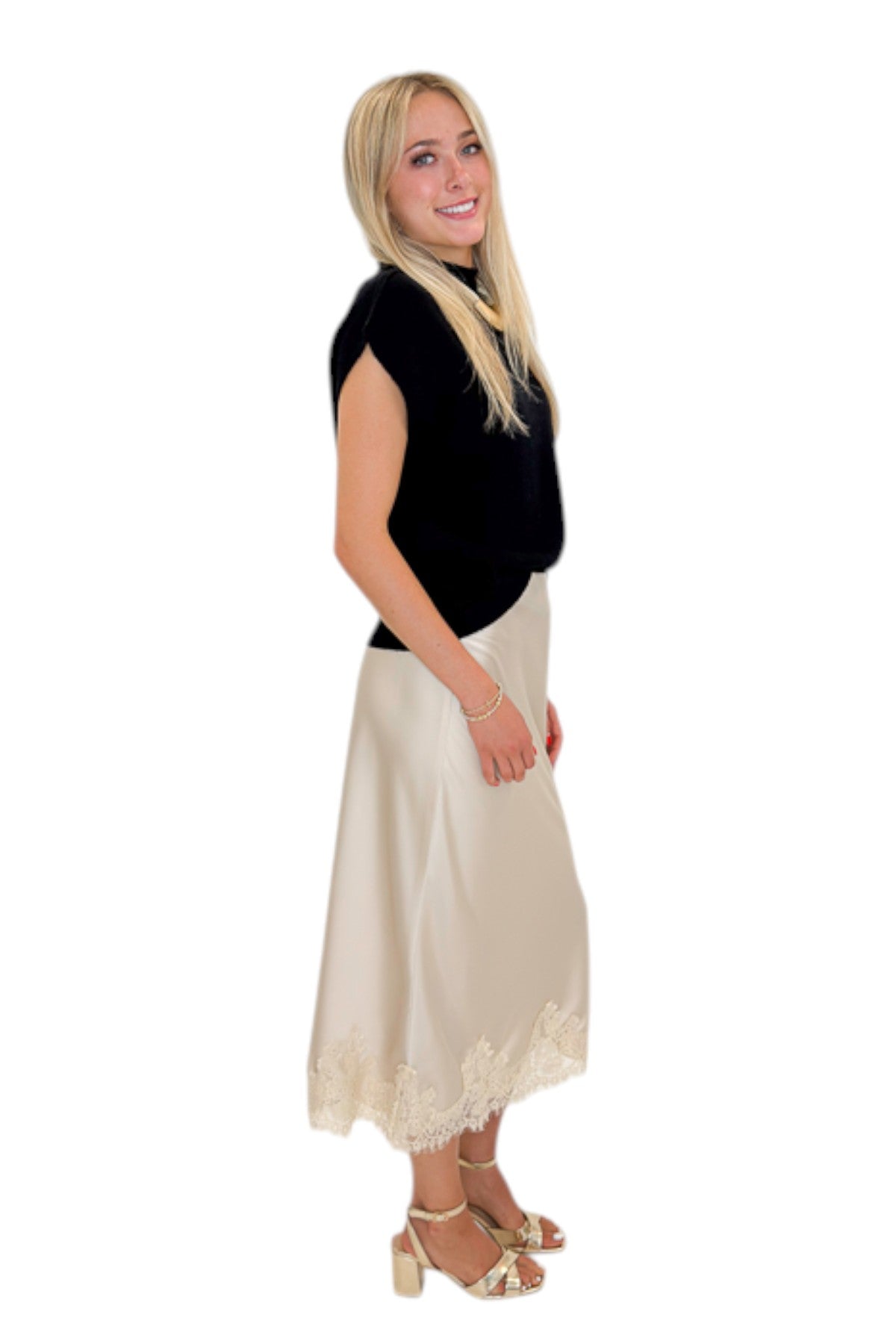 Side view of woman wearing Swagger Boutique’s Beige Satin &amp; Lace Midi Skirt with heels against white studio background.