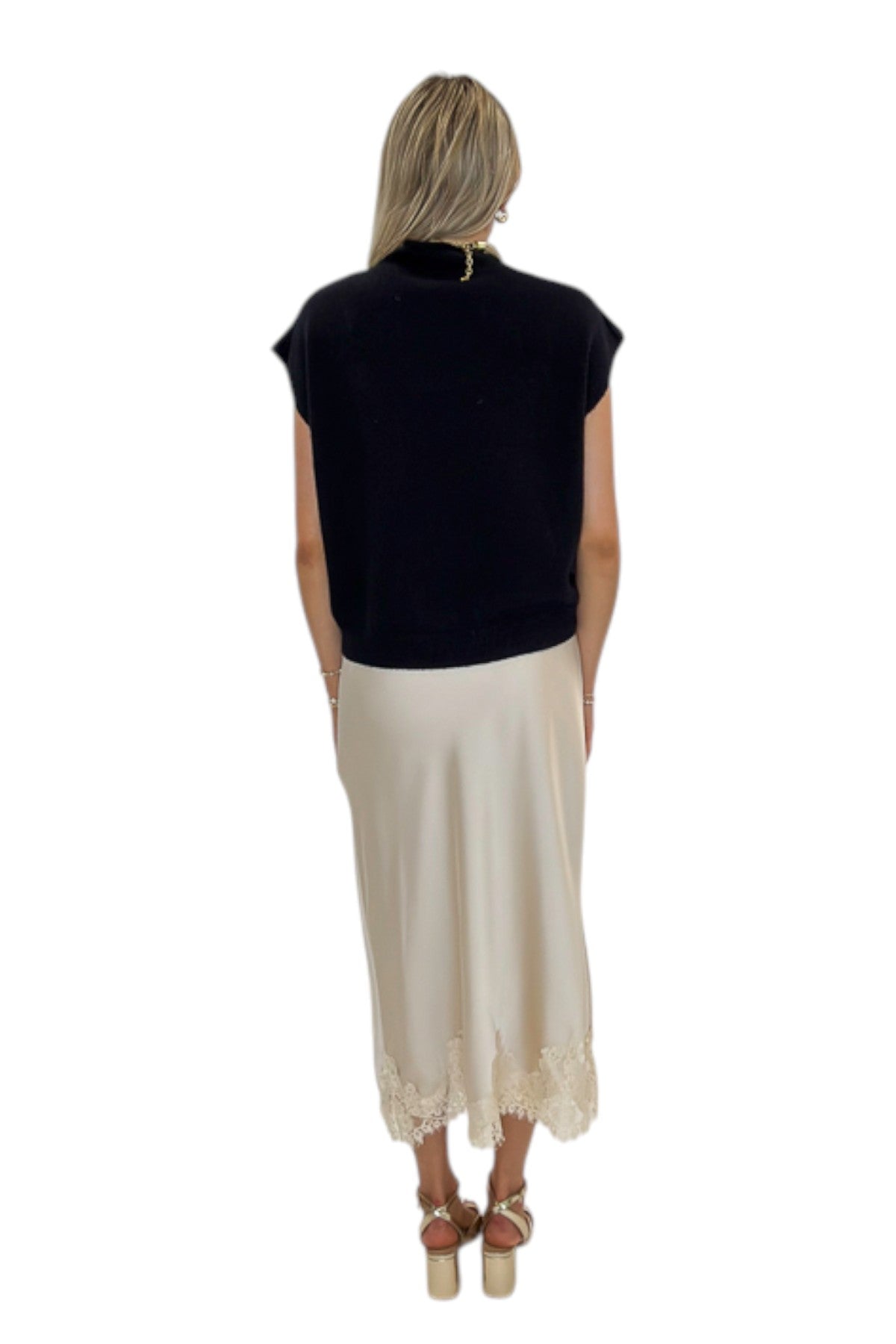 Back view of woman wearing Swagger Boutique’s Beige Satin &amp; Lace Midi Skirt with heels against white studio background.
