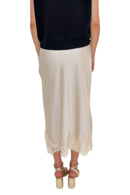 Back view of woman wearing Swagger Boutique’s Beige Satin &amp; Lace Midi Skirt with heels against white studio background.