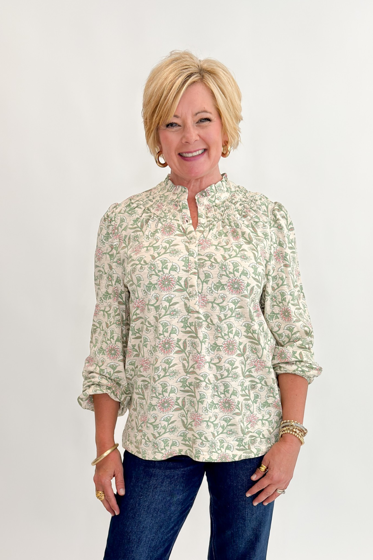 Front view of woman wearing Swagger Boutique’s Beige &amp; Olive Floral Long Sleeve Top with jeans against white studio background.