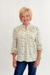 Front view of woman wearing Swagger Boutique’s Beige & Olive Floral Long Sleeve Top with jeans against white studio background.