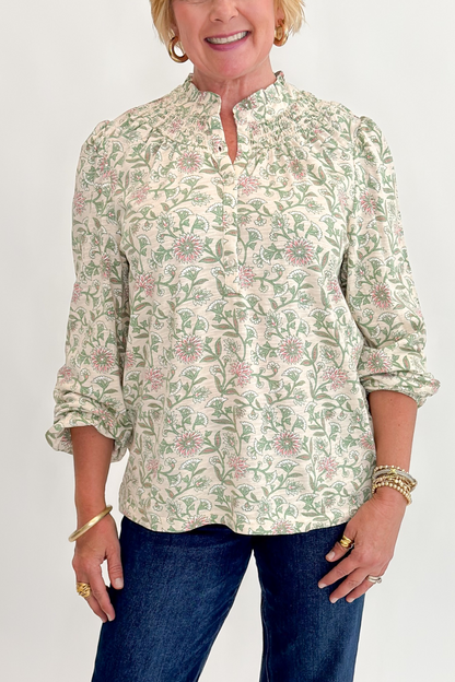 Front detail view of woman wearing Swagger Boutique’s Beige &amp; Olive Floral Long Sleeve Top with jeans against white studio background.