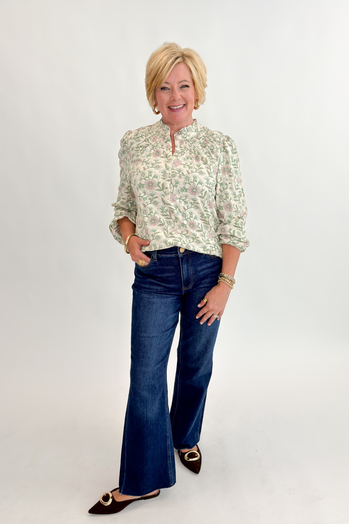 Front view of woman wearing Swagger Boutique’s Beige &amp; Olive Floral Long Sleeve Top with jeans against white studio background.
