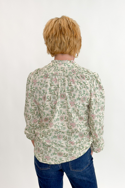 Back view of woman wearing Swagger Boutique’s Beige &amp; Olive Floral Long Sleeve Top with jeans against white studio background.
