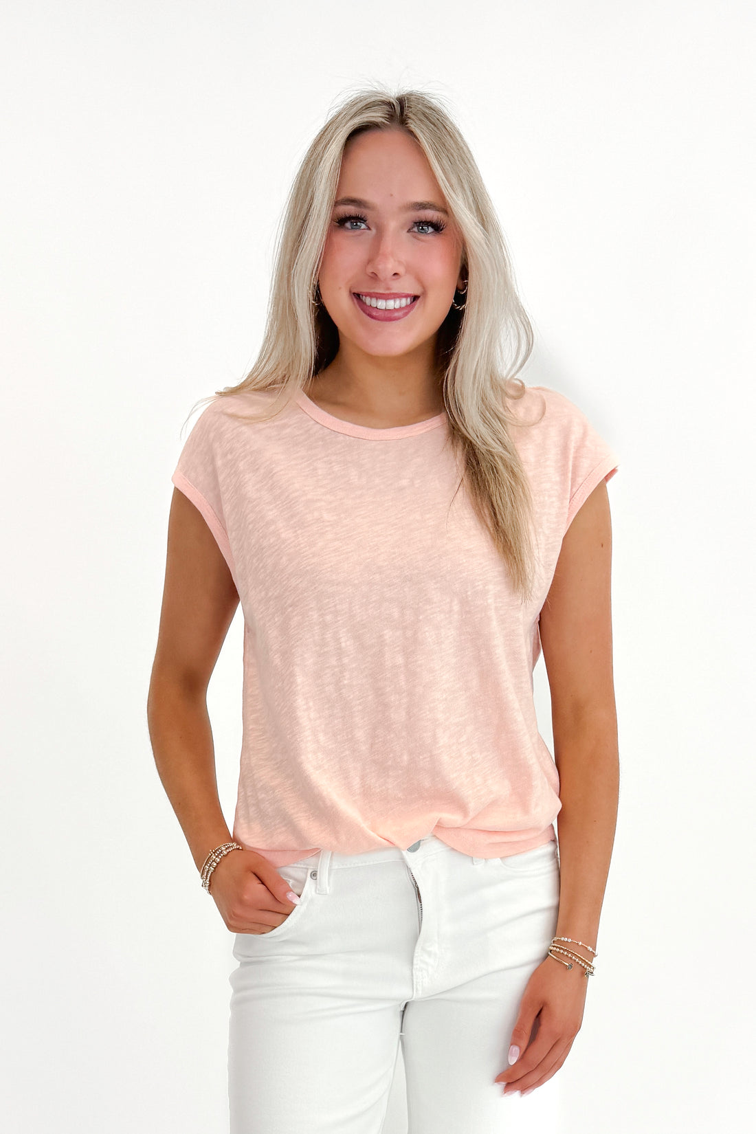 Front view of woman wearing Bellini Sol Slub Tank by Z Supply with jeans against white studio background.
