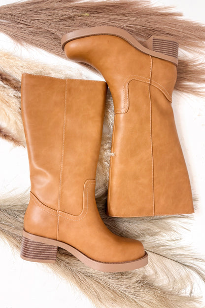 Pair of tan high boots on a white background