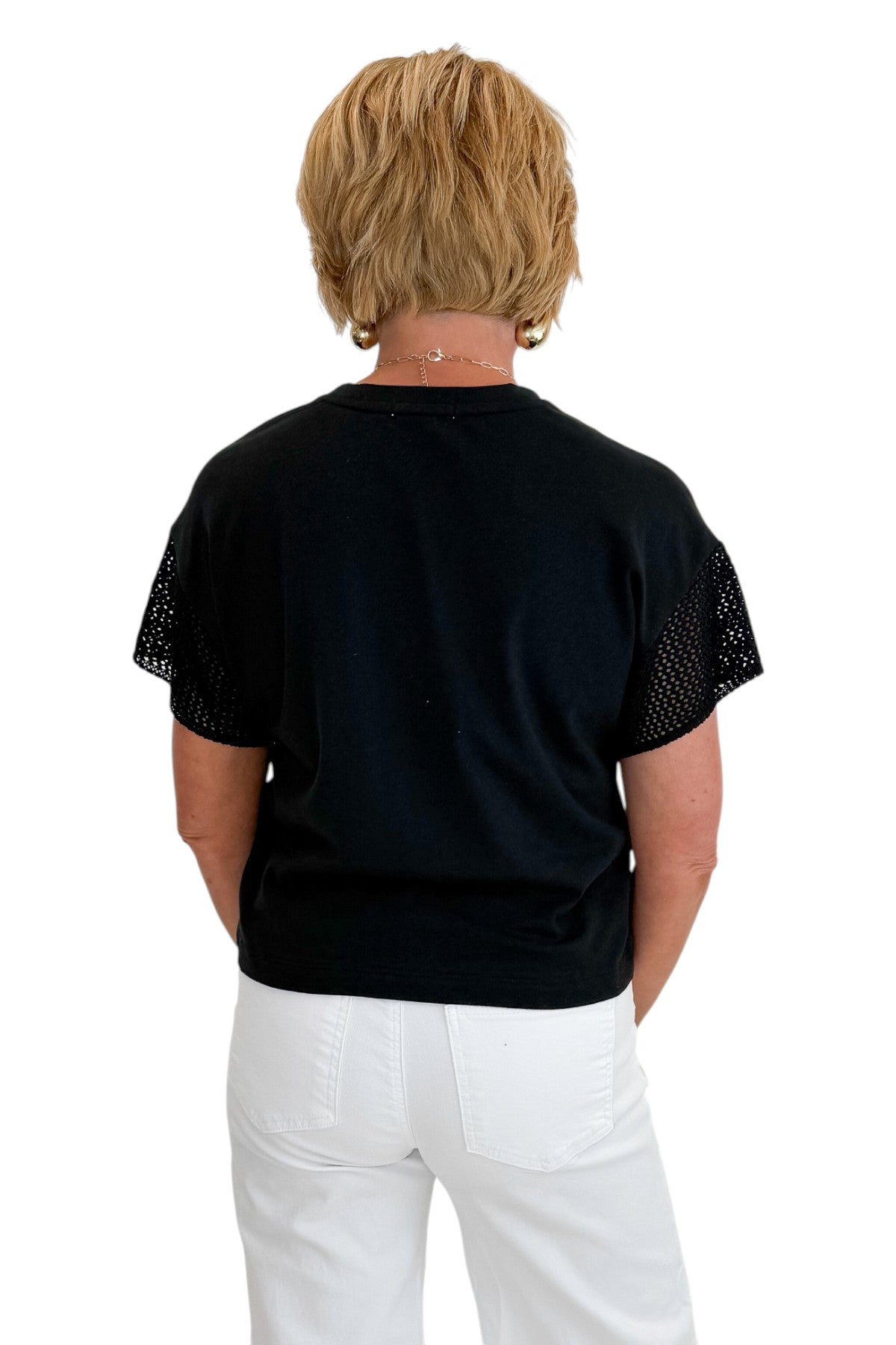 Back view of woman wearing Swagger Boutique’s Black Banyan Top by Z Supply with jeans against white studio background.