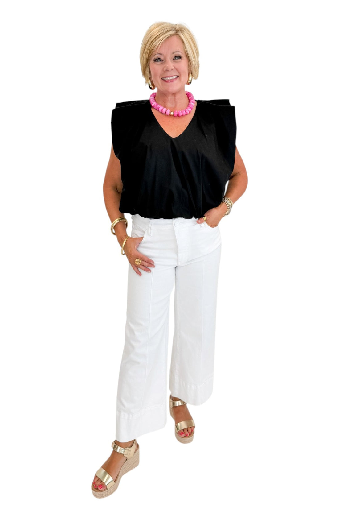 Front view of woman wearing Swagger Boutique’s Black Bubble Hem Pleated Top with jeans against white studio background.