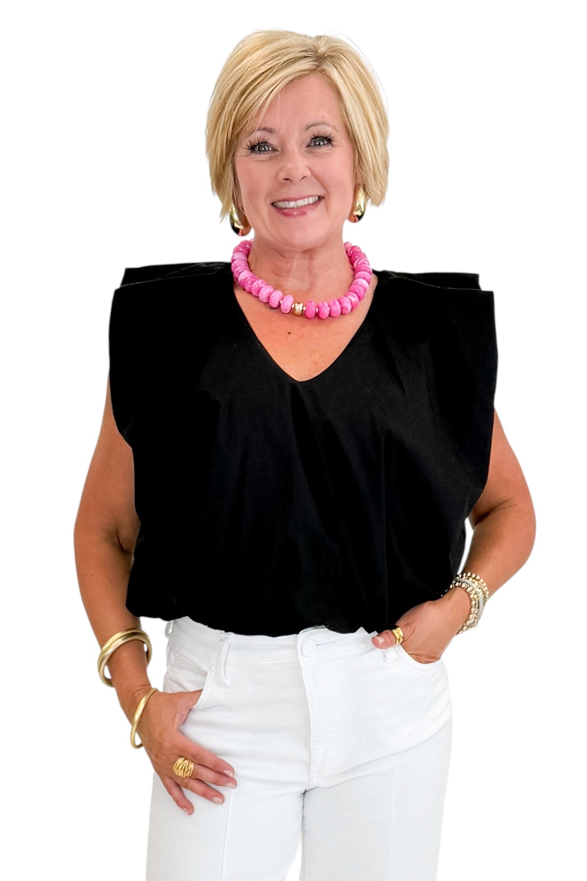 Front view of woman wearing Swagger Boutique’s Black Bubble Hem Pleated Top with jeans against white studio background.