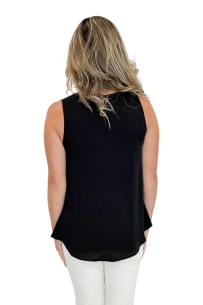 Back view of woman wearing Swagger Boutique’s Black Bubble Hem Tank with jeans against white studio background.